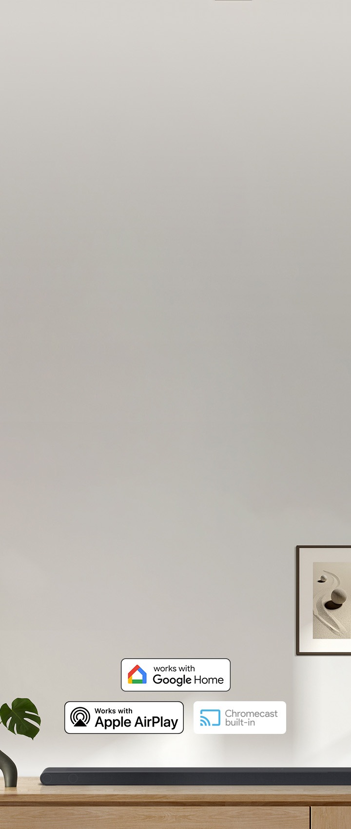 장식장 위에 사운드바가 올려져 있습니다. 사운드바 위에는 구글홈, 애플 에어플레이, 크롬캐스트 빌트인 아이콘이 있습니다.