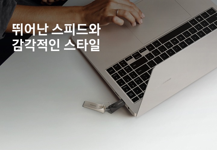 화이트 색상의 책상 위에 제품을 연결한 노트북을 올려두고 한 손으로 작업을 하고 있는 모습을 위에서 내려본 이미지입니다. 이미지 왼쪽 상단부분에는 약간 어두운 부분이 있고 그 위에 뛰어난 스피드와 감각적인 스타일 텍스트가 적혀 있습니다.