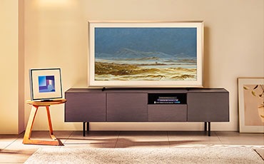 장식장 위에 TV가 설치되어 있으며, 왼쪽에는 작은 테이블 위에 화이트 베젤이 장착된 뮤직 프레임이 놓여 있습니다.