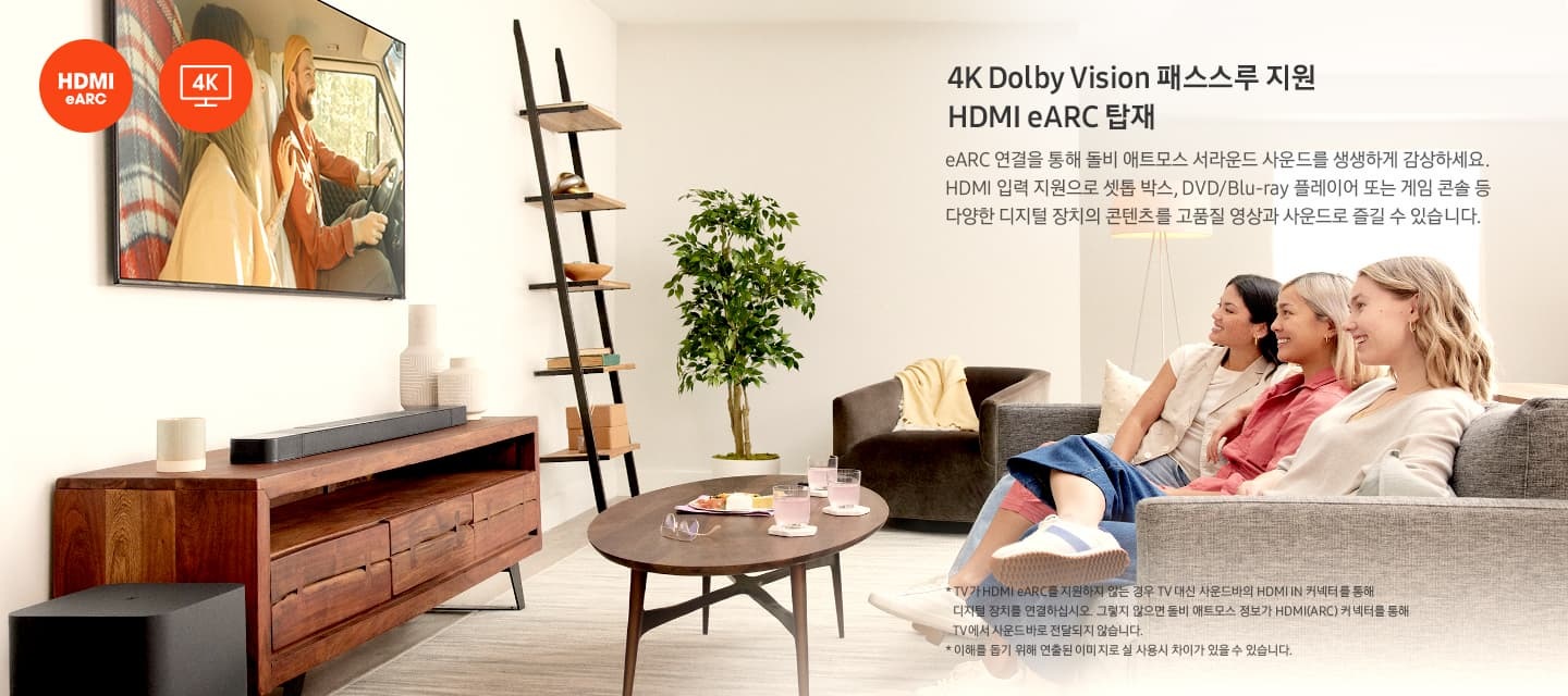 넓은 거실에 여성 세 명이 소파에 모여 앉아 정면에 있는 TV를 시청하고 있습니다.  이는 애트모스 서라운드 사운드로 셋톱박스, DVD,블루레이 플레이어 또는 게임 콘솔 등 다양한 디지털 장치를 지원하고 있어 고품질 영상 및 사운드로 즐길 수 있음을 설명하고 있습니다.  