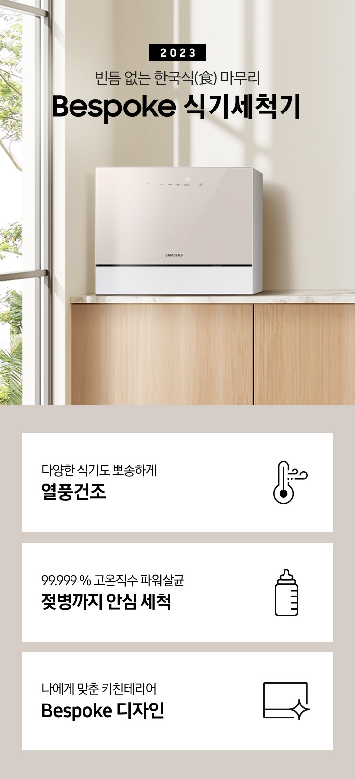 우드 패널 주방 왼쪽엔 창문이 보이고 상판 위 카운터탑 이 올려져 있습니다. 우측에는 2023 빈틈 없는 한국식 마무리 BESPOKE 식기세척기 라는 슬로건이 적여 있고 싱크대 오른쪽엔 수전과, 나무 도마 3개가 있습니다. 그 위 선반에는 작은 식물이 있는 화분과 새 모양의 오브제가 올려져 있습니다.