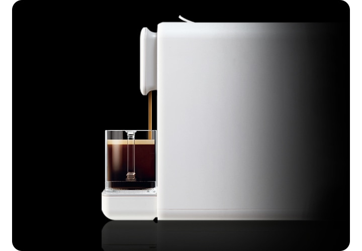 카누 캡슐커피머신 바리스타 페블 화이트의 측면으로 머신 위 머그잔에 에스프레소와 물이 한번에 추출되는 연출 이미지입니다.