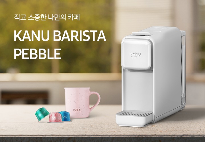 아일랜드 식탁 위 우측에 카누 바리스타 페블 화이트 캡슐 커피머신이 놓여있습니다. 머신 좌측에는 분홍색 카누 머그잔과 카누 캡슐커피머신 전용 캡슐 3개가 놓여있습니다. 좌측에는 문구가 나와있습니다. 작고 소중한 나만의 카페. KANU BARISTA PEBBLE.