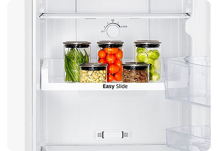 냉장고 하칸 내상 이지 슬라이브 선반 위에 반울양배추와 방울 토마토, 견과류 등이 담긴 병이 놓여있습니다.