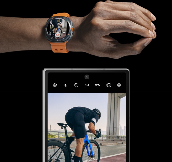 갤럭시 워치 울트라를 착용한 손이 엄지와 검지 두 번 맞대기 동작을 하고 있습니다. 그 옆에는 갤럭시 Z 폴드6가 페어링되어 있고, 한 남성이 자전거를 타는 모습을 담은 카메라 화면이 커버 스크린과 짝을 이루고 있습니다.