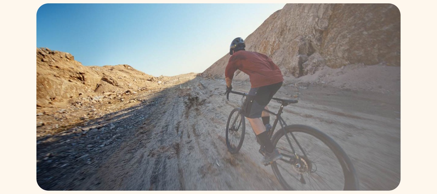 바위가 많은 오솔길에서 자전거를 탄 사람이 앞을 촬영하고 있습니다. 손목에는 갤럭시 워치 울트라를 차고 있습니다.