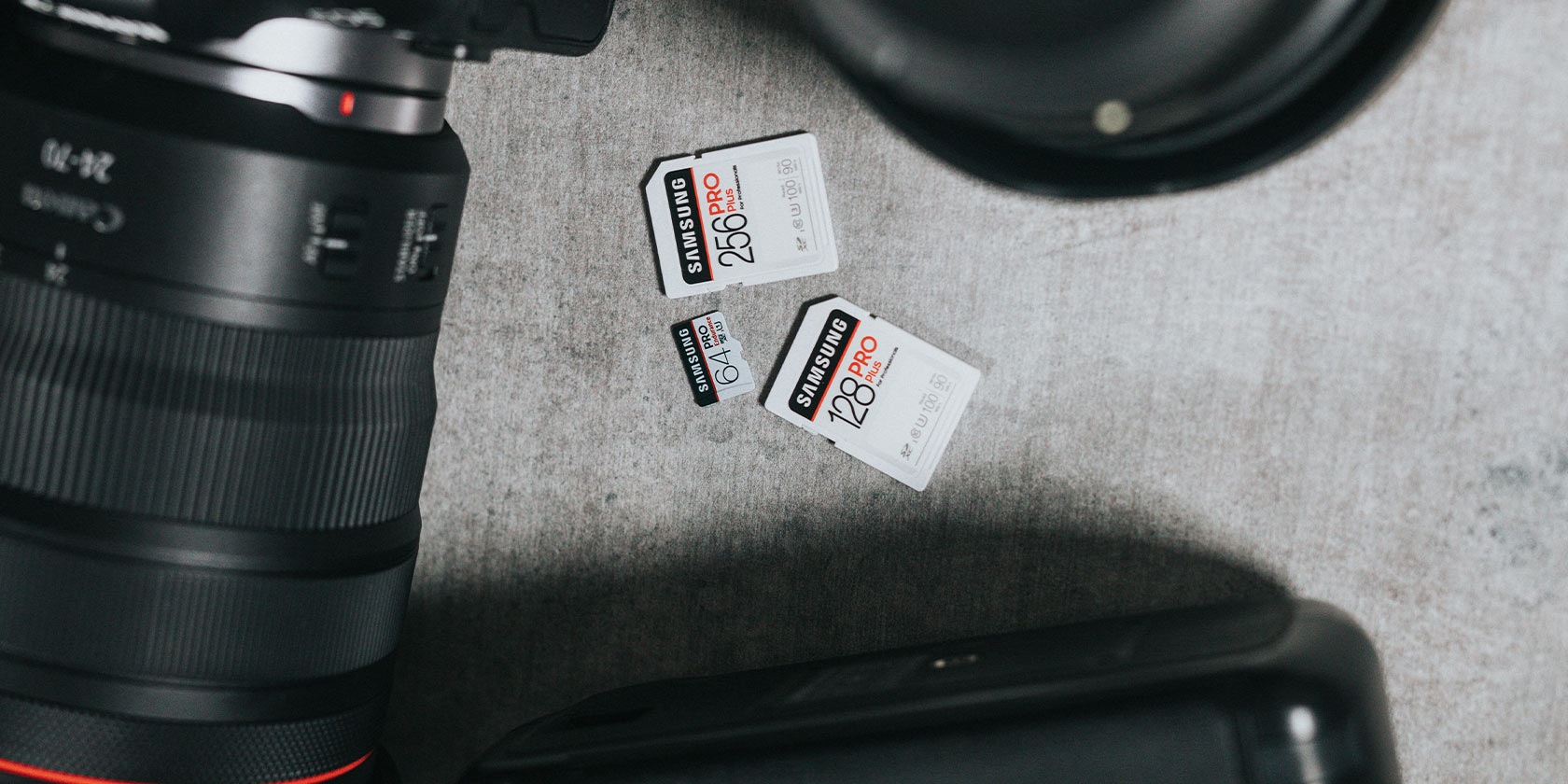 64, 128, 256 GB의 PRO Plus 제품이 바닥에 있고 주변에 카메라가 있습니다.