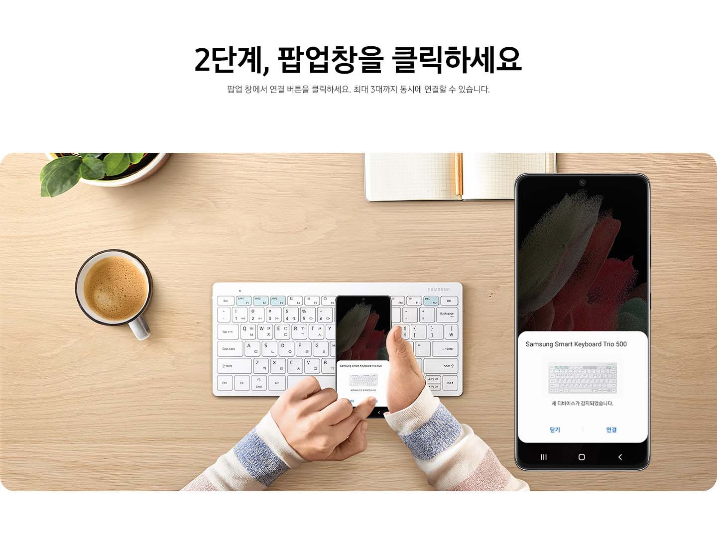 책상 가운데에 키보드 위에 스마트폰에 블루투스를 연결하여 키보드가 감지된 이미지가 보여집니다. 오른쪽에는 스마트폰의 내용을 확대하여 보여주고 있습니다.