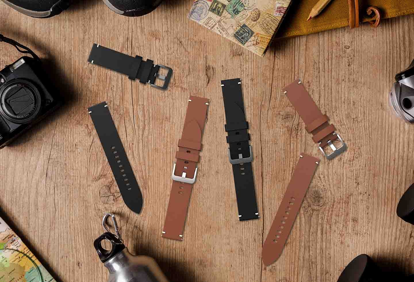 나무 느낌의 책상에 갤럭시 워치 브랄로바 스트랩 (와이드) 블랙 색상과 다크 브라운 색상을 다양한 방향으로 나열해 놓은 이미지