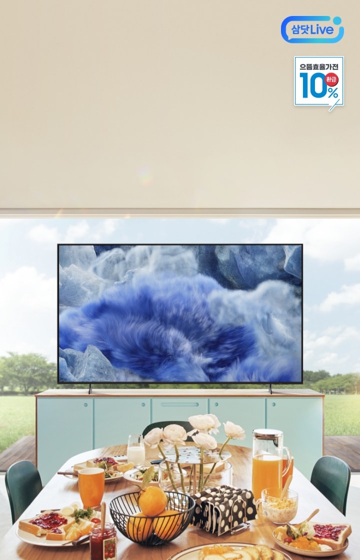 [밝은 자연광이 들어오는 거실 공간에 큰 창 너머로 푸른 하늘과 잔디밭이 보이며, 중앙에는 2025 QLÉD~ 4K TV가 선반 위에 놓여 있고, 우측 상단에는 '~으뜸효율가전 10% 환급' 태그가 표시되어 있다 + 우측상단 삼닷 Lív~é 로고]