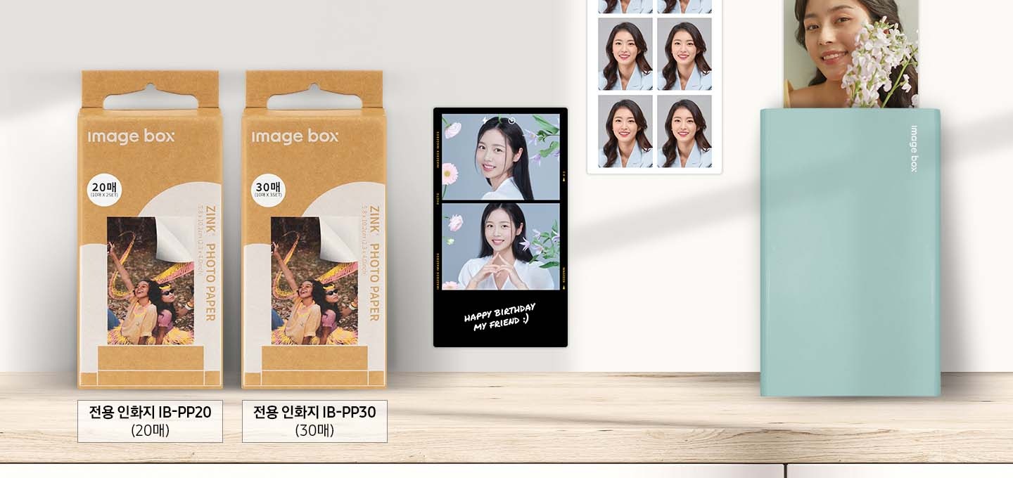 이미지 왼쪽 부분에는 포토 프린터 용지 30 매, 포토 프린터 용지 20 매 제품의 정면 이미지가 있으며 각각 제품 이미지 하단에는 전용 인화지 IB-PP30 (30매), 전용 인화지 IB-PP20 (20매) 텍스트가 적혀있습니다. 이미지 오른쪽 부분에는 모바일 포토 프린터 (블루) 제품에서 꽃을 들고 있는 여성 이미지가 출력되고 있고 이미지 중간 부분에는 사진은 위아래로 2가지를 출력할 수 있게 편집한 후에 출력한 여성의 이미지가 있습니다.