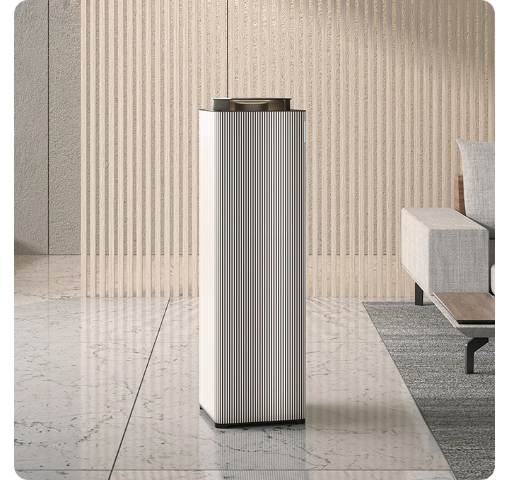 거실 대리석 바닥 위에 공기청정기 있습니다, 공기청정기 우측 뒤에는 소파가 보입니다.