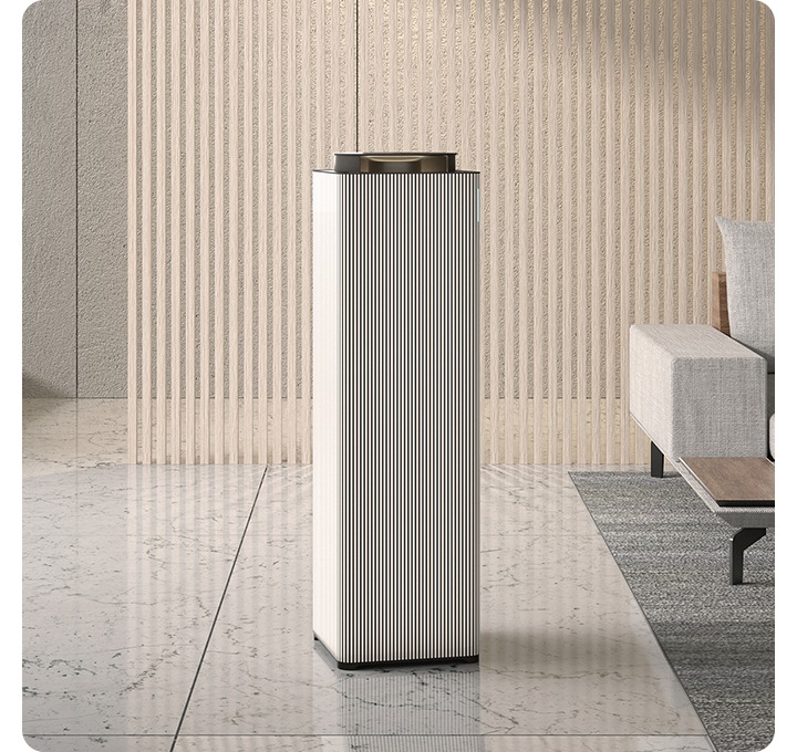 거실 대리석 바닥 위에 공기청정기 있습니다, 공기청정기 우측 뒤에는 소파가 보입니다.