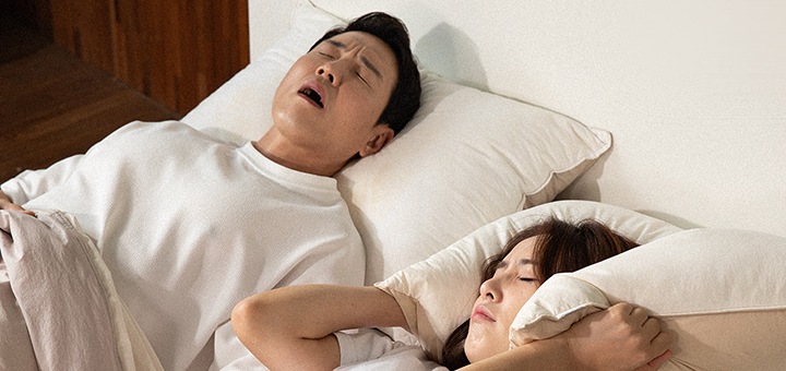 코고는 남자와 코골이에 괴로워하는 여자의 이미지