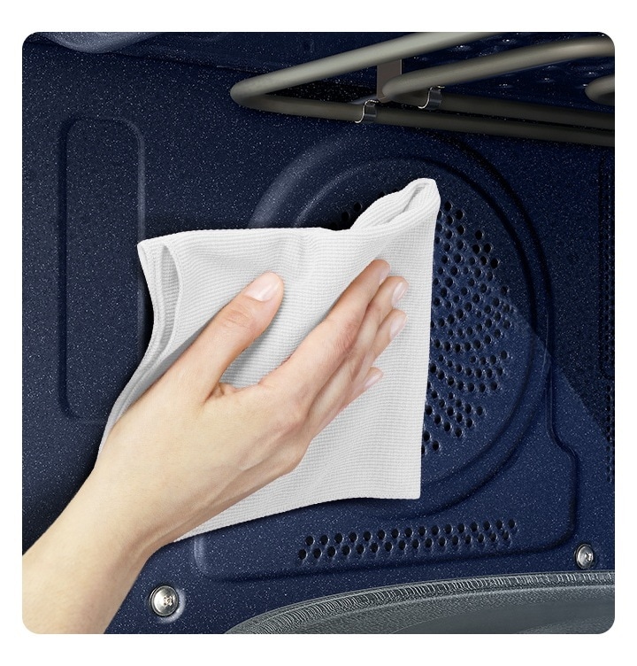 Bespoke 직화오븐 35L 의 내부 조리실 벽면이 확대되어 보여지고 있으며, 마른 수건으로 벽면을 닦고 있는 사람의 손이 보여지는 연출된 이미지입니다.