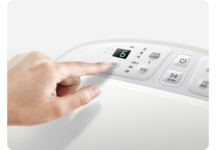 아가사랑의 상단 조작부 모습입니다. 손으로 행굼 횟수 설정 버튼을 누르고 있습니다.