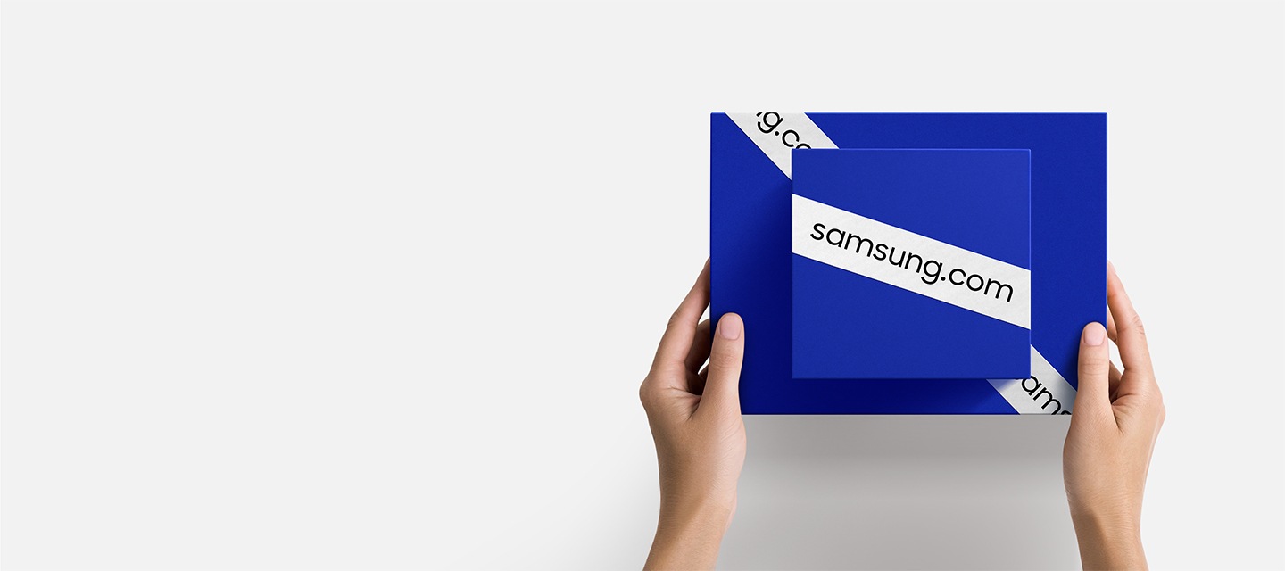 samsung.com 이라고 쓰인 띠가 둘러져 있는 파란색 상자 두 개를 겹쳐서 들고 있는 손이 보입니다.