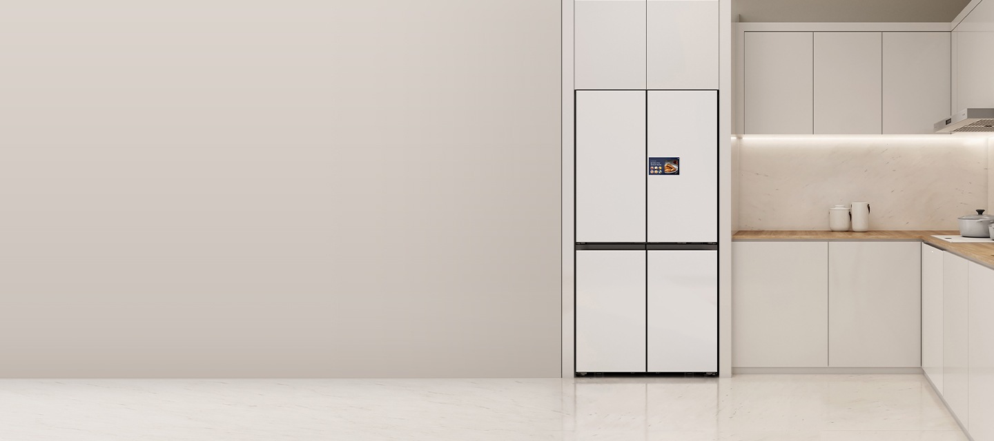 주방 중앙 우측에 삼성 Bespoke AI 패밀리허브 냉장고가 빌트인 되어 있고, 냉장고 우측에는 상하부장이 있습니다. 상부장 위엔 그릇과 냄비가 있습니다.