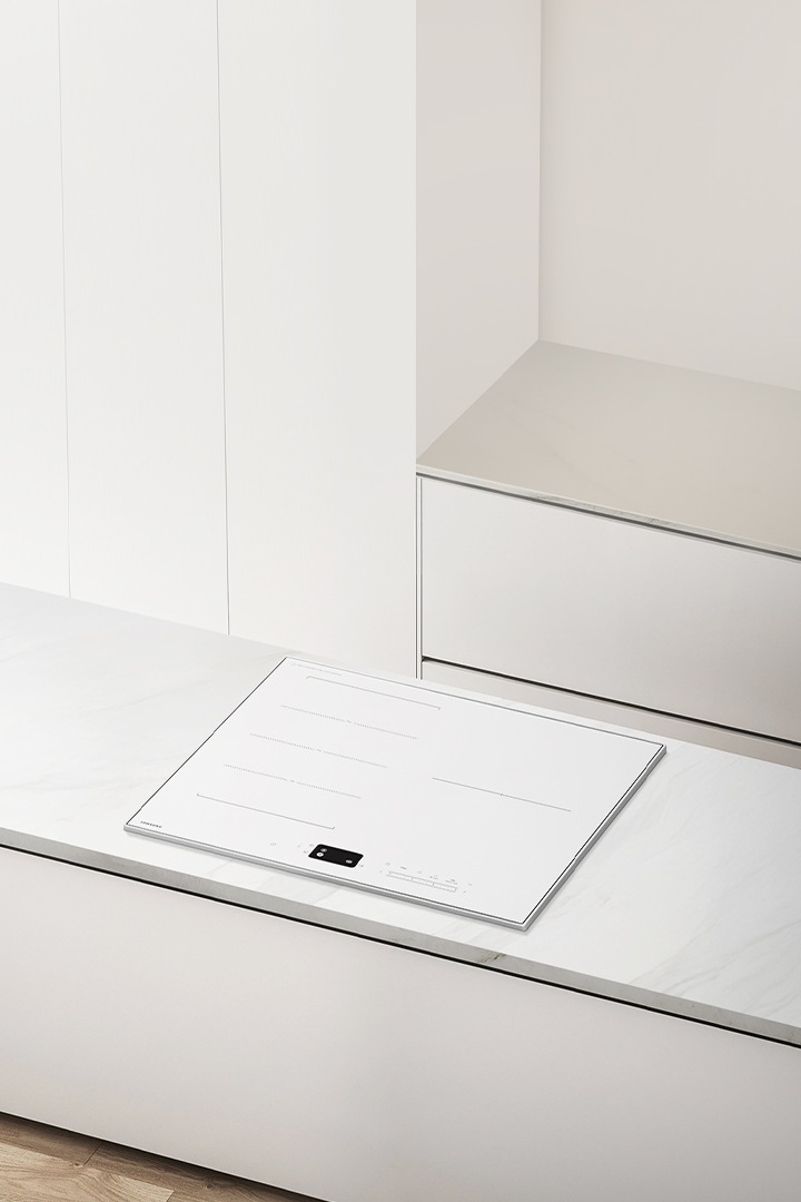 베이지색 마루 바닥에 화이트톤 아일랜드 식탁, 아일랜드 식탁 위에 화이트톤 일체형 인덕션이 설치되어 있는 이미지