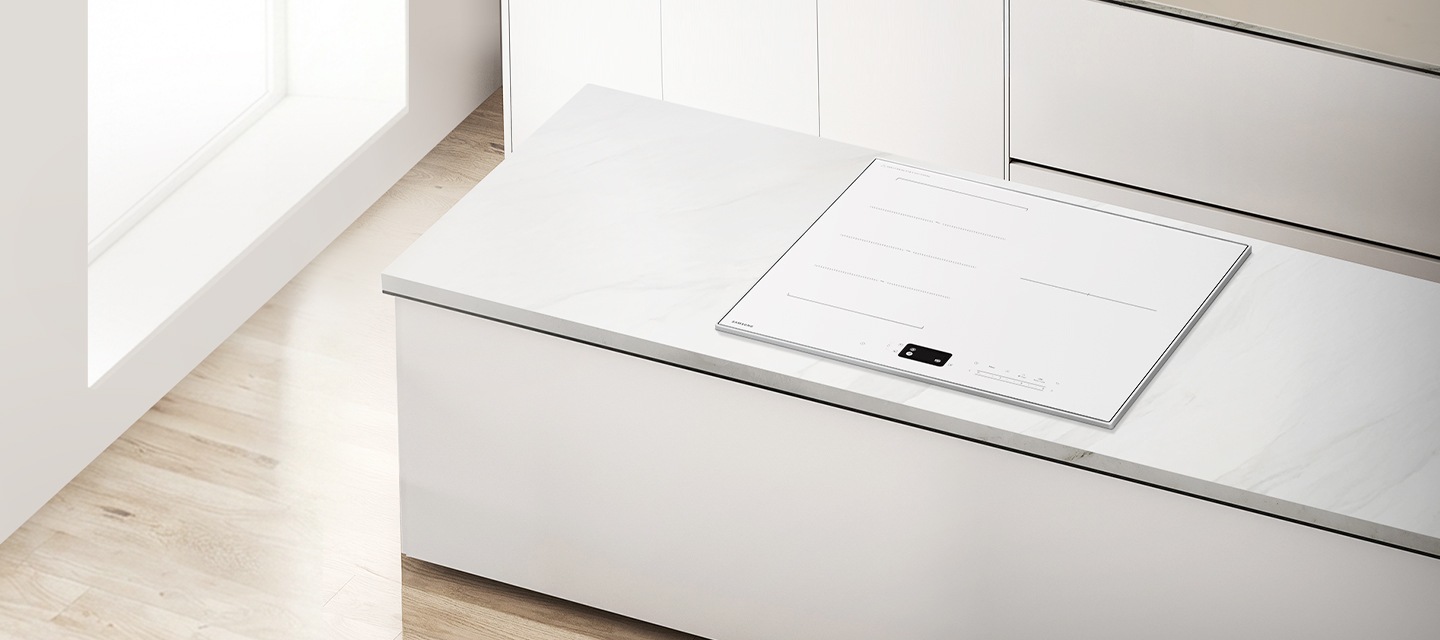 베이지색 마루 바닥에 화이트톤 아일랜드 식탁, 아일랜드 식탁 위에 화이트톤 일체형 인덕션이 설치되어 있는 이미지