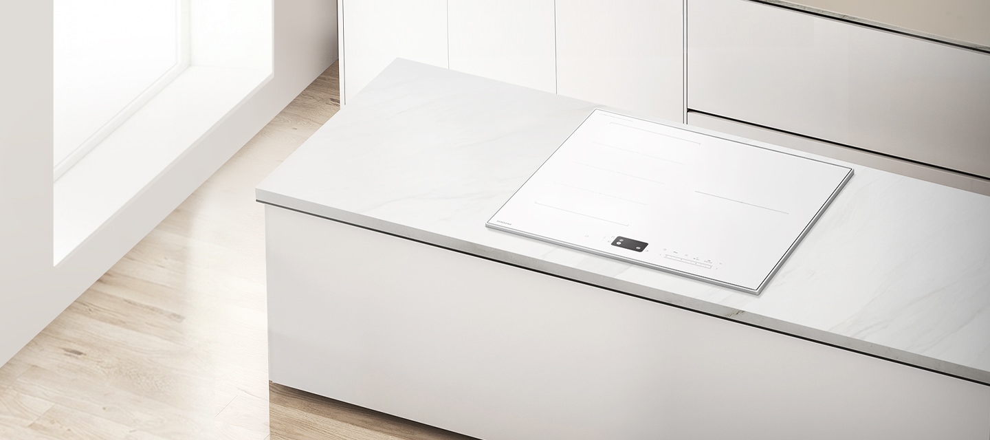 베이지색 마루 바닥에 화이트톤 아일랜드 식탁, 아일랜드 식탁 위에 풀화이트 인덕션이 설치되어 있는 이미지