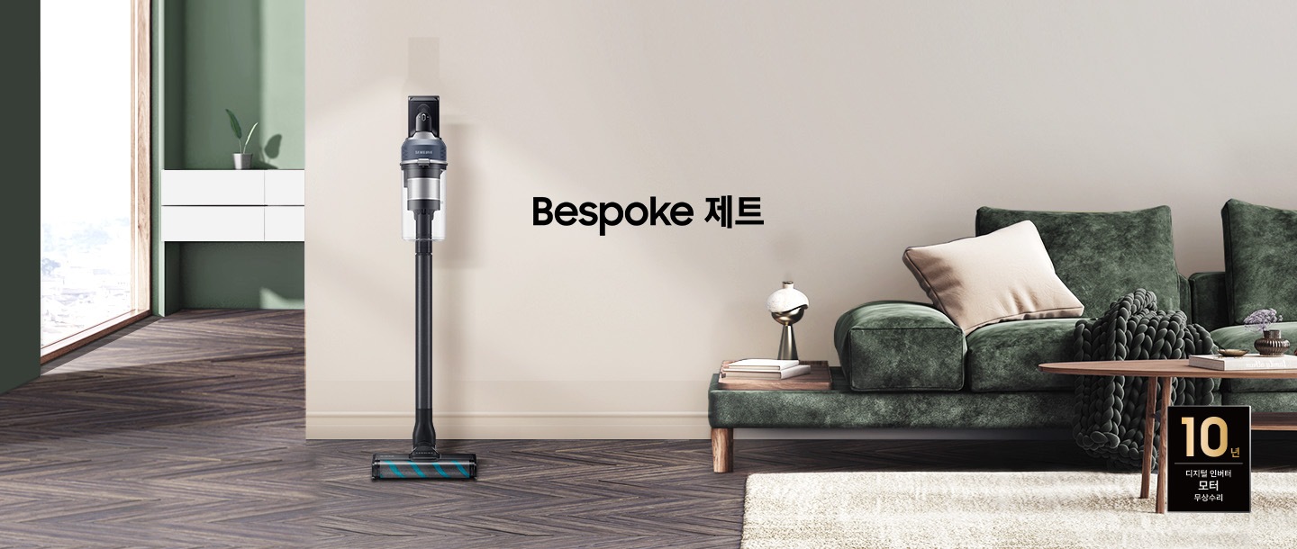 모던한 분위기의 거실을 배경으로 이미지 왼쪽에는 해가 들어오는 넓은 창이 있고 그 옆에는 하얀색 선반형 벽 수납장이 놓여 있습니다.  수납장 위에는 초록 잎 2장이 자라고 있는 작은 화분이 올려져 있습니다. 선반 뒤 쪽 벽은 부드럽고 잔잔한 초록색 톤을 띄고 있습니다. 마루는 헤링본 스타일의 진한 월넛 색상입니다. 정면에 보이는 넓은 벽면은 진한 아이보리 톤을 띄고 있습니다. 이미지 오른쪽에는 진한 그린 색의 패브릭 소파가 있습니다. 소파 위에는 아이보리 톤의 사각 쿠션과 굵은 짜임의 니트 재질 담요가 흘러내리 듯 올려져 있고, 소파 앞에는 우드 재질의 원형 테이블이 놓여 있습니다.  바닥엔 크림색의 러그가 깔려 있습니다. 소파 왼쪽 끝부분엔 우드 패널 위로 책 두 권과 금색 빛의 오브 재가 있습니다. 거실 전경 가운데에는 Bespoke  제트 문구가 크게 적여있고 문구 왼쪽으로 Bespoke 제트 210W 미드나잇 블루 스틱이 정면을 바라보고 서 있습니다. 이미지 오른쪽 하단 부분에는 디지털 인버터 모터 10년 보증 로고가 반영 되어 있습니다.