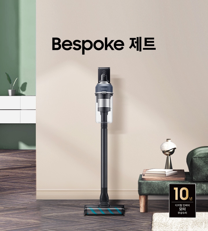 모던한 분위기의 거실을 배경으로 이미지 왼쪽에는 해가 들어오는 넓은 창이 있고 그 옆에는 하얀색 선반형 벽 수납장이 놓여 있습니다.  수납장 위에는 초록 잎 2장이 자라고 있는 작은 화분이 올려져 있습니다. 선반 뒤 쪽 벽은 부드럽고 잔잔한 초록색 톤을 띄고 있습니다. 마루는 헤링본 스타일의 진한 월넛 색상입니다. 정면에 보이는 넓은 벽면은 진한 아이보리 톤을 띄고 있습니다. 이미지 오른쪽에는 진한 그린 색의 패브릭 소파가 있습니다. 소파 위에는 아이보리 톤의 사각 쿠션과 굵은 짜임의 니트 재질 담요가 흘러내리 듯 올려져 있고, 소파 앞에는 우드 재질의 원형 테이블이 놓여 있습니다.  바닥엔 크림색의 러그가 깔려 있습니다. 소파 왼쪽 끝부분엔 우드 패널 위로 책 두 권과 금색 빛의 오브 재가 있습니다. 거실 전경 가운데에는 Bespoke  제트 문구가 크게 적여있고 문구 왼쪽으로 Bespoke 제트 210W 미드나잇 블루 스틱이 정면을 바라보고 서 있습니다. 이미지 오른쪽 하단 부분에는 디지털 인버터 모터 10년 보증 로고가 반영 되어 있습니다.