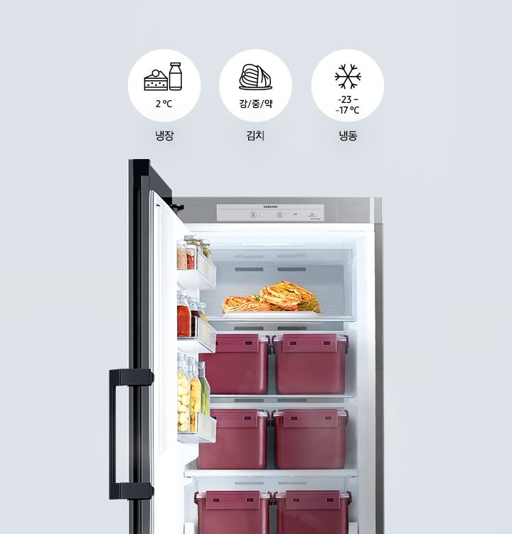 냉장고 도어가 열려있고 내부는 김치통과 다양한 김치들로 가득차 있습니다. 위에는 냉장, 김치, 냉동문구와 함께 이를 표현하는 아이콘들이 그려져 있으며 냉장은 2°C, 김치는 강/중/약, 냉동은 -23~-17°C 문구가 아이콘 아래에 적혀 있습니다. 배경 색상은 그레이입니다.