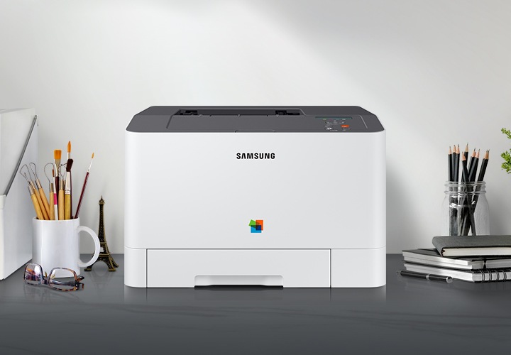 제품 정면이 그레이 색상의 책상 위에 올려져 있고 주변에 사무용품들이 배치되어 있습니다.