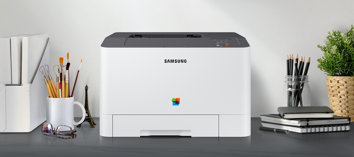 제품 정면이 그레이 색상의 책상 위에 올려져 있고 주변에 사무용품들이 배치되어 있습니다.