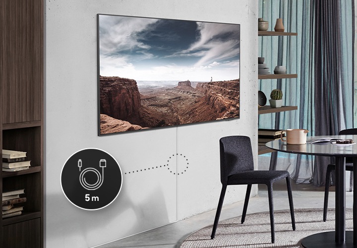 거실에 벽걸이 TV 가 설치되어 있습니다. TV 화면에서는 자연 화면이 나오고 있고, 하단에는 매직케이블이 설치되어 있습니다. 케이블 중간 부분에는 5 m 아이콘이 추가되어 있습니다.