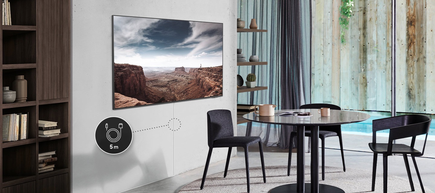 거실에 벽걸이 TV 가 설치되어 있습니다. TV 화면에서는 자연 화면이 나오고 있고, 하단에는 매직케이블이 설치되어 있습니다. 케이블 중간 부분에는 5 m 아이콘이 추가되어 있습니다.