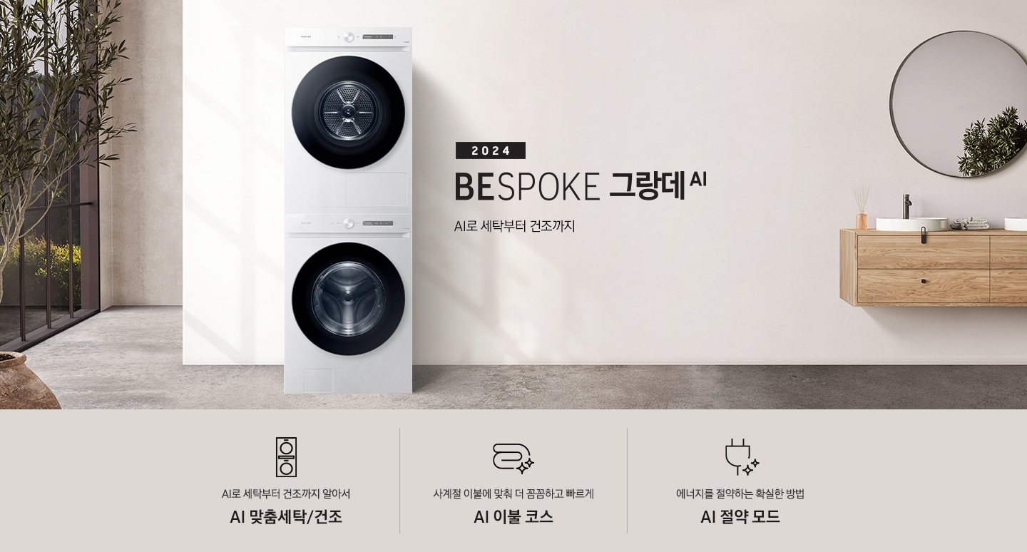 모던한 세탁실에 설치된 BESPOKE 그랑데 세탁기 + 건조기 AI 제품의 모습입니다. 왼쪽에는 나무와 유리창이 보이고, 오른쪽에는 세면대와 거울이 보입니다. 아래에는 AI로 세탁부터 건조까지 알아서 AI 맞춤세탁/건조 문구와 아이콘, 사계절 이불에 맞춰 더 꼼꼼하고 빠르게 AI 이불 코스 문구와 아이콘, 에너지를 절약하는 확실한 방법 AI 절약 모드 문구와 아이콘이 있습니다.