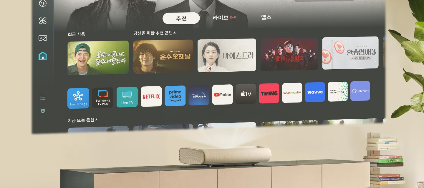 벽에 제품으로 삼성 TV Plus를 틀었습니다. 화면에는 콩심은데 콩나고 팥심은데 팥난다, 운수 오진날, 마에스트라 등 다양한 예능과 드라마 화면이 보입니다.