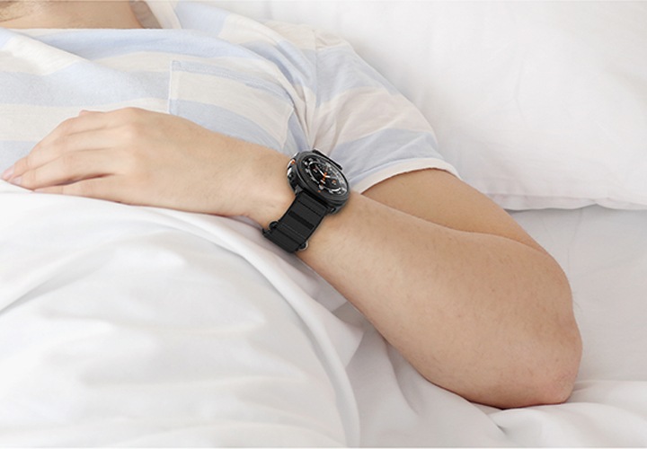 침대에 이불을 덮고 갤럭시 워치 울트라 벨크로 밴드를 착용 후 누워있는 사람의 손목 부분을 확대한 이미지가 보이고 있습니다.