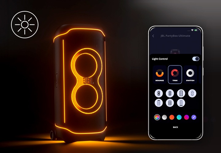 왼쪽에는 어두운 배경에 주황색 라이트가 켜진 제품이 있습니다. 오른쪽에는 스마트폰이 있으며, 화면에는 JBL One 앱 화면 중 Light Control 화면이 노출되고 있습니다.