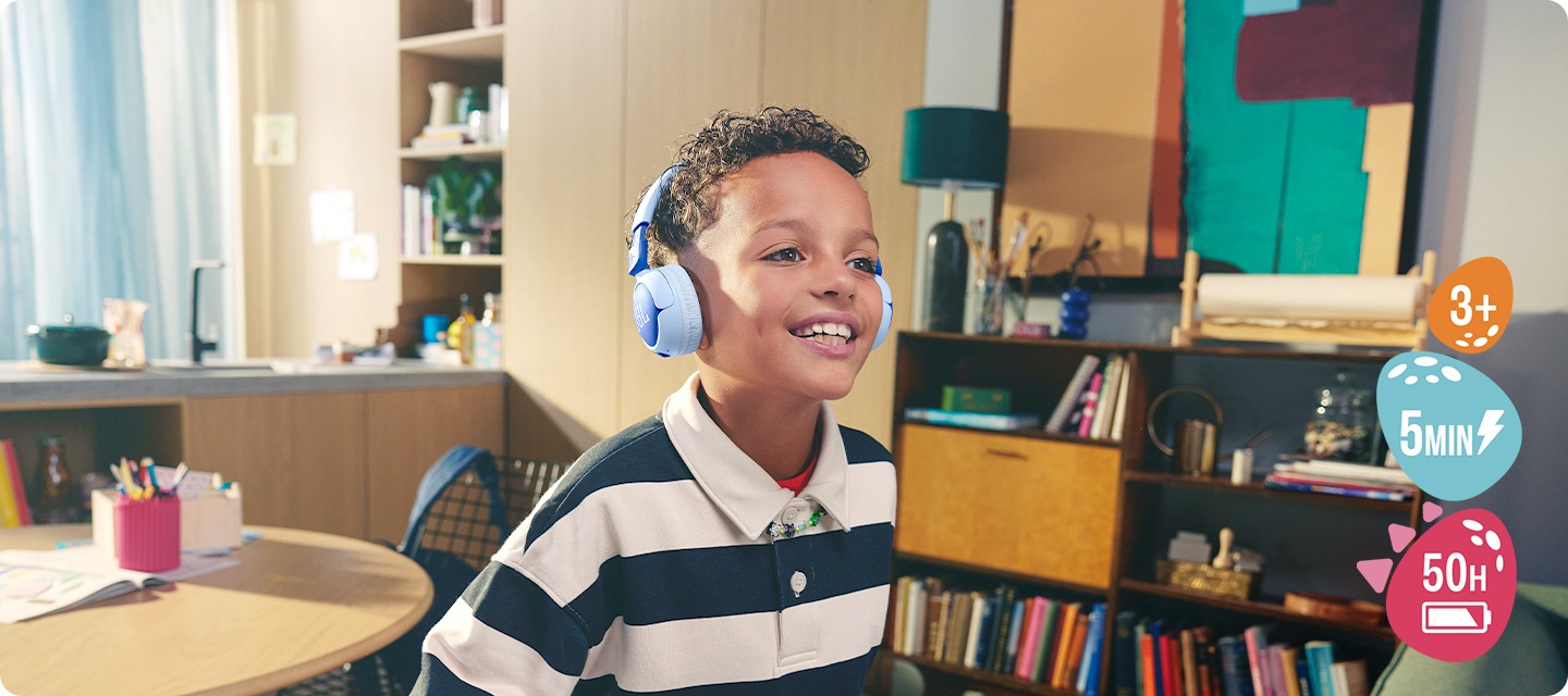 남자아이가 제품을 착용한 체 웃고 있습니다. 아이 뒤로는 주방공간과 테이블, 책장과 소품들이 보입니다.