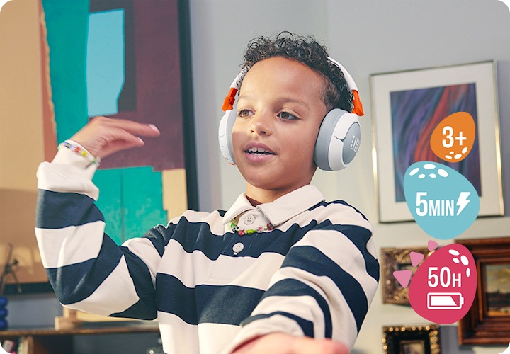 남자 아이가 제품을 착용한 상태로 춤을 추고 있습니다. 아이 뒤 벽에는 액자들이 걸려 있습니다.