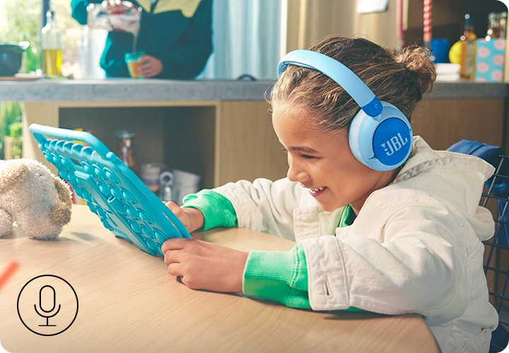 제품을 착용한 여자 아이가 테이블에 앉아 태블릿 PC를 보고 있습니다.