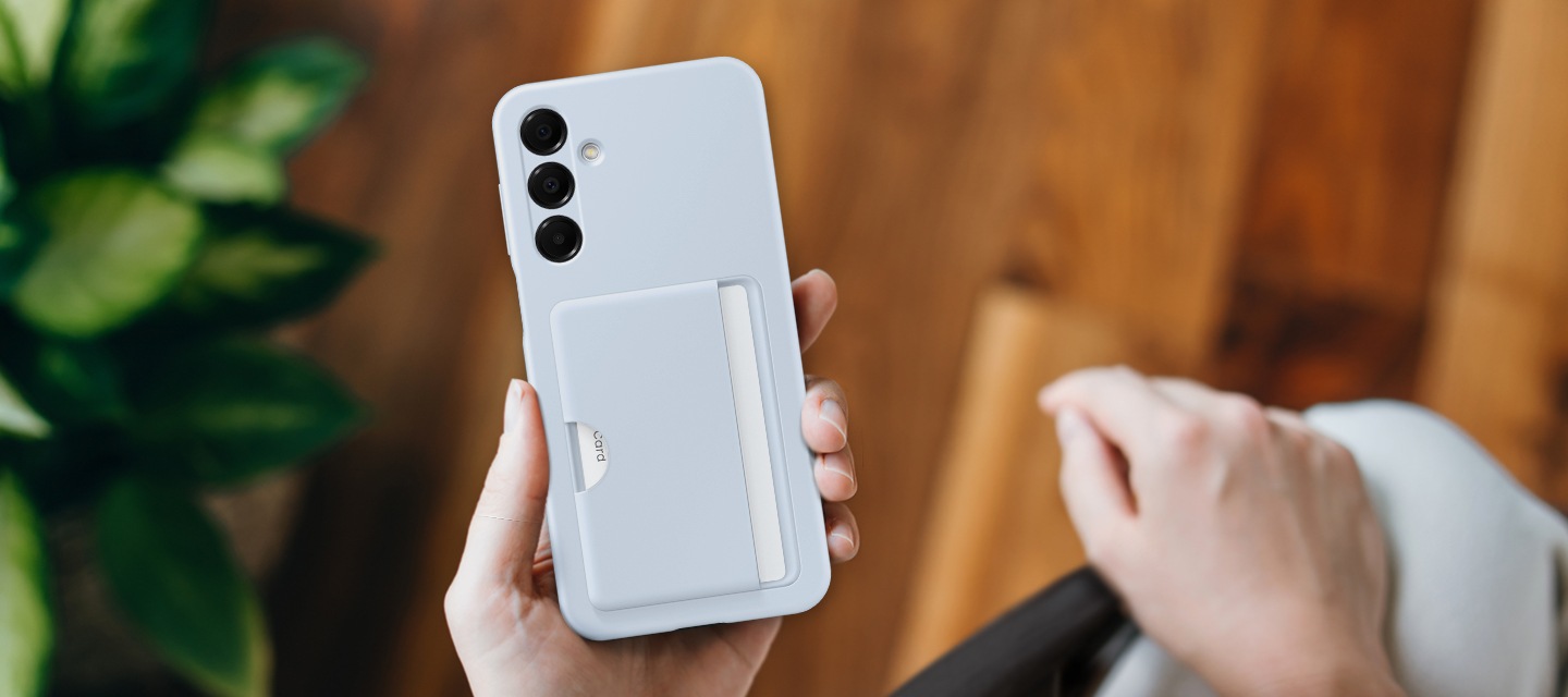 블루 색상의 카드 슬롯 케이스를 착용한 갤럭시 A16이 있습니다. 케이스에 신용카드를 넣은 기기를 손에 들고 있습니다.