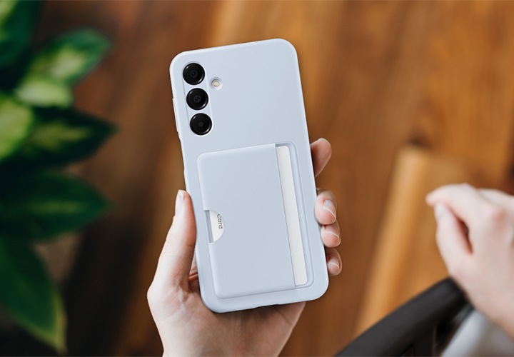 블루 색상의 카드 슬롯 케이스를 착용한 갤럭시 A16이 있습니다. 케이스에 신용카드를 넣은 기기를 손에 들고 있습니다.