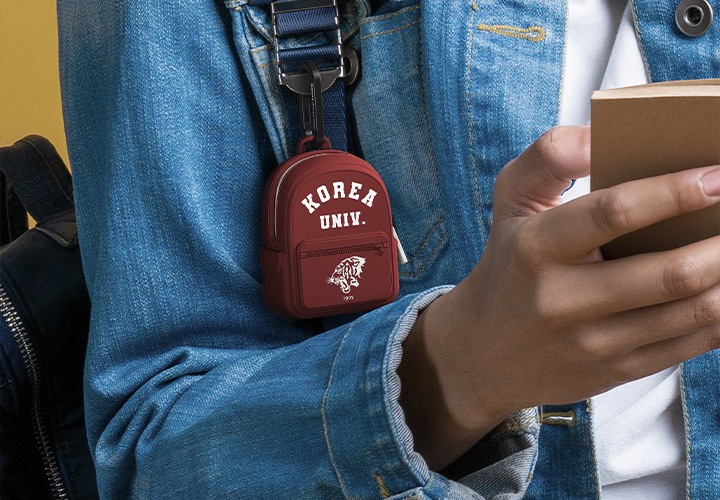 학생이 수첩을 들고 가방은 맨 상태에서, 제공하는 카라비너를 통해 가방에 걸린 본 제품의 모습이 보입니다.