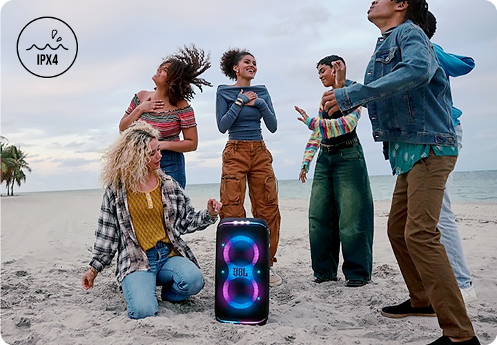 해변에 제품이 놓여 있으며, 그 주변에는 사람들이 모여서 춤을 추고 있습니다.