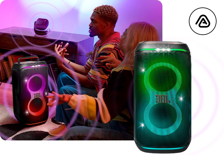 거실 소파에 사람들이 앉아 있습니다. 사람들 사이에는 제품이 놓여 있으며, 제품에서 음파가 나오고 있습니다. 오른쪽 하단에 제품의 정면 컷이 보입니다.