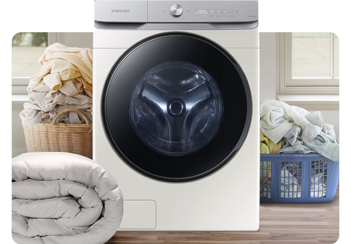 인테리어컷 가운데 그랑데 세탁기 AI가 놓여있습니다. 세탁기 좌측에는 라탄 바구니에 빨래가 가득 쌓여있고 그 앞에는 이불이 개어져 있습니다. 세탁기 우측에는 파란색 플라스틱 바구니 안에 수건 등 빨랫감이 가득 쌓여있는 연출된 이미지 입니다.