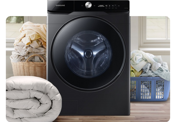 인테리어컷 가운데 그랑데 세탁기 AI가 놓여있습니다. 세탁기 좌측에는 라탄 바구니에 빨래가 가득 쌓여있고 그 앞에는 이불이 개어져 있습니다. 세탁기 우측에는 파란색 플라스틱 바구니 안에 수건 등 빨랫감이 가득 쌓여있는 연출된 이미지 입니다.