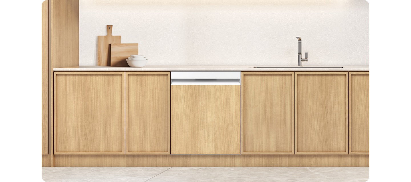 식기세척기가 설치되어 있는 인테리어 컷 입니다. 베이지톤 싱크대 위에 수전이 보이고 도마와 그릇이 놓여있습니다. 우드톤의 하부장에는 식기세척기가 설치되어 있는 연출된 인테리어 입니다.