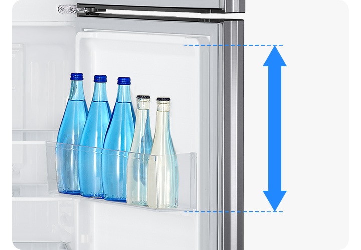 냉장고 내상 우측 도어빈에 우유병과 물병이 들어있고 빅가드의 높이를 파란색 화살표로 나타낸 연출된 이미지 입니다.
