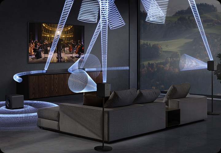 거실 벽에 TV가 설치되어 있습니다. TV 아래에는 장식장이 있으며, 그 위에 사운드바가 설치되어 있습니다. 장식장 왼쪽 바닥에는 서브 우퍼가 소파 뒤 스탠드에 무선 리어 스피커가 설치되어 있으며, 사운드바와 서브 우퍼, 무선 리어 스피커에서 음향효과가 나오고 있습니다.