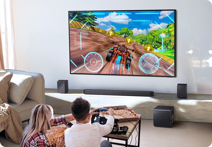 남성과 여성이 거실에 앉아서 게임을 즐기고 있습니다.